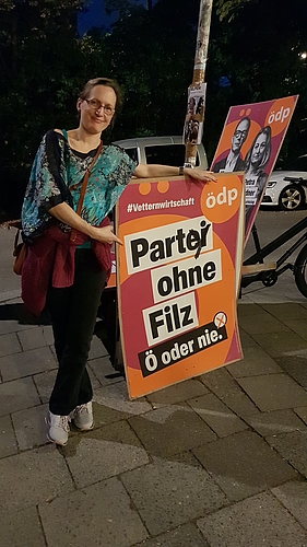 Charlotte Schmid vor überschriebenem Wahlplakat: "Part(ei)y ohne Filz"