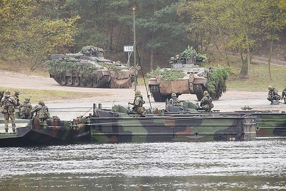 Pioniere der Bundeswehr bauen eine Brücke über einen  Fluss