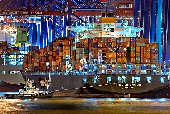 Riesiges Frachtschiff Houston Express im Hamburger Hafen mit kleinem Boot links vom Schiff