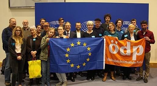 20 Personen vor blauem Hintergrund. Vordere Reihe hält eine EU- und eine ÖDP-Flagge.